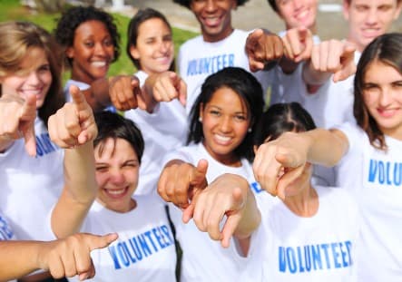 Group of volunteers pointing forward